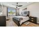 Cozy main bedroom boasts wood floors, ample natural light and a ceiling fan at 9316 Crescent Ray Dr, Wesley Chapel, FL 33545