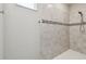 Modern tiled shower featuring a tiled accent stripe and adjustable shower head at 9316 Crescent Ray Dr, Wesley Chapel, FL 33545