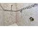 Modern tiled shower featuring a tiled accent stripe and adjustable shower head at 9316 Crescent Ray Dr, Wesley Chapel, FL 33545