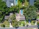 An aerial view shows a home with a pool and mature trees in a neighborhood with well-maintained lawns at 9403 Bellhaven St, Temple Terrace, FL 33637