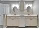 Bright bathroom featuring a white double vanity with mirrors and plenty of cabinet space for storage at 9403 Bellhaven St, Temple Terrace, FL 33637