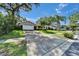 Spacious driveway leading to a well-maintained home surrounded by lush greenery and mature trees at 9403 Bellhaven St, Temple Terrace, FL 33637