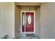 Close-up of a red front door with decorative glass, a 'Welcome Home' mat, and outdoor lighting at 9403 Bellhaven St, Temple Terrace, FL 33637