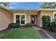 Inviting entrance with a large window, manicured bushes, and a paved walkway to the front door at 9403 Bellhaven St, Temple Terrace, FL 33637