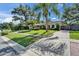 Beautifully landscaped front yard with lush green grass and mature trees surrounding the property at 9403 Bellhaven St, Temple Terrace, FL 33637