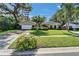 Charming single-story home with a well-manicured lawn, mature trees, and an attached two-car garage at 9403 Bellhaven St, Temple Terrace, FL 33637