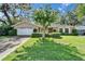 Charming home with a well-maintained lawn, mature landscaping, and a two-car garage at 9403 Bellhaven St, Temple Terrace, FL 33637