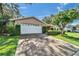 Attached two-car garage with a spacious driveway and manicured landscaping at 9403 Bellhaven St, Temple Terrace, FL 33637