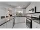 Kitchen featuring stainless steel appliances, granite countertops, with white cabinets and eat in island at 9403 Bellhaven St, Temple Terrace, FL 33637