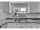 Kitchen sink and granite countertops with stainless steel faucet and white cabinets at 9403 Bellhaven St, Temple Terrace, FL 33637