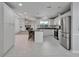 Bright kitchen featuring white cabinets, stainless steel appliances, granite countertops, and bar-style seating at 9403 Bellhaven St, Temple Terrace, FL 33637