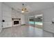 Bright living room showcasing a stone fireplace, built-in shelving and sliding glass doors leading to a pool at 9403 Bellhaven St, Temple Terrace, FL 33637