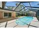 Screened-in pool area with clear blue water, seamlessly blending indoor and outdoor living at 9403 Bellhaven St, Temple Terrace, FL 33637