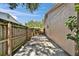 A side yard showing a private area with a wood fence and concrete pathway, offering a secluded outdoor space at 9403 Bellhaven St, Temple Terrace, FL 33637