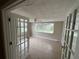Bright, airy bonus room with tile flooring and French doors, offering a flexible space for work or relaxation at 9411 Rainbow Ln, Port Richey, FL 34668