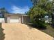 This home has a well-maintained yard, a driveway, and mature landscaping at 9411 Rainbow Ln, Port Richey, FL 34668
