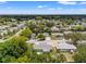 Aerial view of neighborhood with mature trees, well-maintained homes, and a nearby lake at 10039 Old Hickory Ln, Port Richey, FL 34668