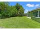 View of a spacious backyard with lush lawn, mature trees, and a fenced perimeter at 10039 Old Hickory Ln, Port Richey, FL 34668