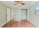 Cozy bedroom with wood floors, an open closet, and a ceiling fan at 10039 Old Hickory Ln, Port Richey, FL 34668