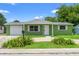 Single-story home featuring a freshly painted exterior, attached garage, and meticulously maintained landscaping at 10039 Old Hickory Ln, Port Richey, FL 34668