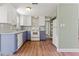 Modern kitchen with stainless steel appliances, granite countertops, and a combination of white and blue cabinets at 10039 Old Hickory Ln, Port Richey, FL 34668