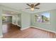 Inviting living room with fresh floors, new paint, a ceiling fan and a large window for natural light at 10039 Old Hickory Ln, Port Richey, FL 34668