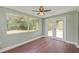Bright sunroom featuring wood floors, a ceiling fan, large windows, and glass doors at 10039 Old Hickory Ln, Port Richey, FL 34668