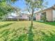 Spacious backyard with lawn, mature trees, and a patio area, perfect for relaxation and entertainment at 10323 Birdwatch Dr, Tampa, FL 33647