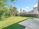Beautifully maintained backyard with lush green lawn, privacy fence, and screened-in pool view at 10323 Birdwatch Dr, Tampa, FL 33647