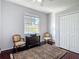 Well-lit bedroom with large window, dresser, chairs, and closet at 10323 Birdwatch Dr, Tampa, FL 33647