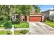 Charming single-Gathering home with a well-manicured front lawn and a two-car garage at 10323 Birdwatch Dr, Tampa, FL 33647