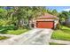 Well-maintained home featuring a two-car garage, landscaping, and a cozy front porch at 10323 Birdwatch Dr, Tampa, FL 33647