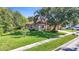Landscaped home featuring a two-car garage, mature trees, and a large lawn at 10323 Birdwatch Dr, Tampa, FL 33647