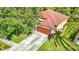 Aerial view of home with a brown garage door, lush landscaping, and a concrete driveway at 10323 Birdwatch Dr, Tampa, FL 33647