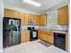 Bright kitchen features oak cabinets, tile floors, and black appliances at 10323 Birdwatch Dr, Tampa, FL 33647