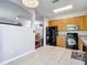 Open concept kitchen with natural wood cabinets and black appliances, tile floor at 10323 Birdwatch Dr, Tampa, FL 33647