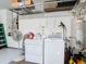 Clean laundry area featuring a washer, dryer, and overhead storage shelves in the garage at 10323 Birdwatch Dr, Tampa, FL 33647