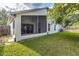 Exterior view of the home's screened patio and spacious green backyard at 10364 Lightner Bridge Dr, Tampa, FL 33626