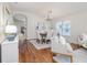 Bright dining room featuring wood floors, modern chandelier, and large window with views of the backyard at 10364 Lightner Bridge Dr, Tampa, FL 33626