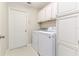 Well-organized laundry room with white cabinets, modern appliances, and a door to the outside at 10364 Lightner Bridge Dr, Tampa, FL 33626