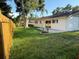 The backyard features green grass, a small garden, sliding glass doors, and a wood fence at 10999 Del Prado E Dr, Largo, FL 33774