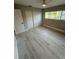 This bedroom features light gray floors, a ceiling fan, natural light, and a closet at 10999 Del Prado E Dr, Largo, FL 33774