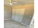 Neutral bedroom with new floors, a ceiling fan, and closet doors at 10999 Del Prado E Dr, Largo, FL 33774