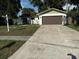 Charming single-story home with a spacious driveway and well-maintained front lawn and beautiful landscaping at 10999 Del Prado E Dr, Largo, FL 33774