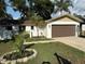 Charming home with a new garage door and an inviting front lawn with beautiful landscaping at 10999 Del Prado E Dr, Largo, FL 33774