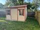 The backyard shed features windows, a door, and red trim at 10999 Del Prado E Dr, Largo, FL 33774