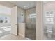 Elegant bathroom featuring a glass shower, neutral tiling, and toilet at 11622 Gleaming Ter, Venice, FL 34293