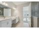 Bright bathroom featuring double sinks, quartz countertop and a glass shower at 11622 Gleaming Ter, Venice, FL 34293