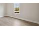 Cozy bedroom with wood-look floors and bright window providing natural light and view of landscaping at 11622 Gleaming Ter, Venice, FL 34293