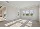 Airy bedroom featuring neutral carpet, tray ceiling, and a wall of windows at 11622 Gleaming Ter, Venice, FL 34293